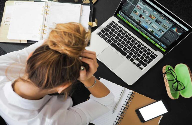 Stressed woman using task management apps and planners at her desk