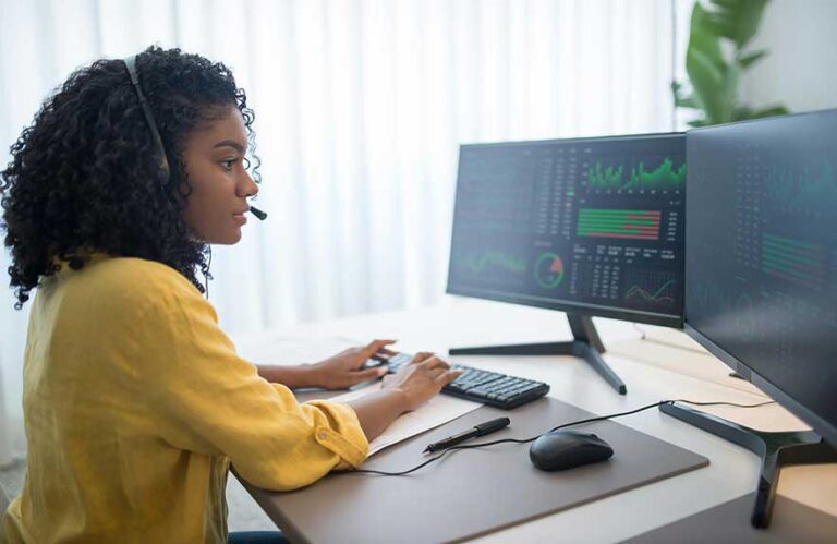 dual monitor setup on windows 11 with woman working at desk with two screens