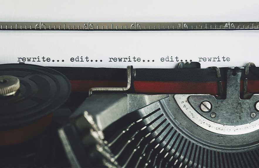 A vintage typewriter typing the phrase “rewrite… edit…” symbolizing long form writing software and distraction-free focus.